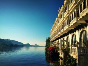 A serene view of a Lake in, India, showcasing its tranquil waters and surrounding hills with a heritage property